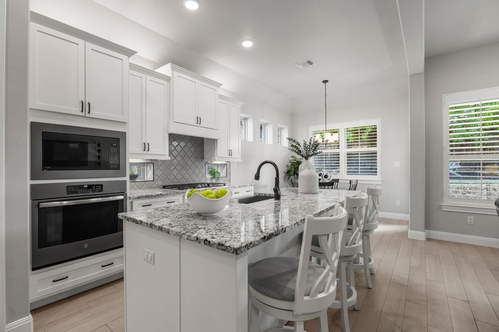 308 Morning Ridge Georgetown, TX 78628 - Photo 3 of 33 a kitchen with stainless steel appliances granite countertop a stove a sink a microwave a dining table and chairs