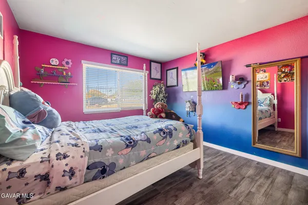 a bedroom with a bed and a dresser with mirror
