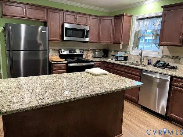 a kitchen with kitchen island granite countertop wooden cabinets and a sink