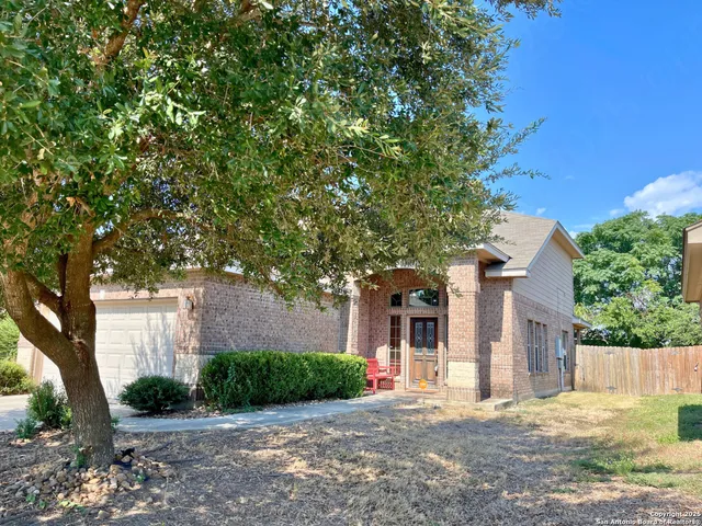 a front view of a house with a yard and potted plants
