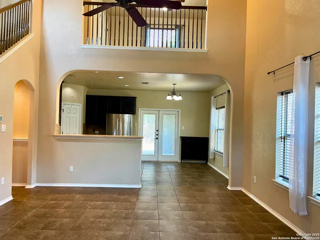 a view of a hallway with wooden floor and a living room