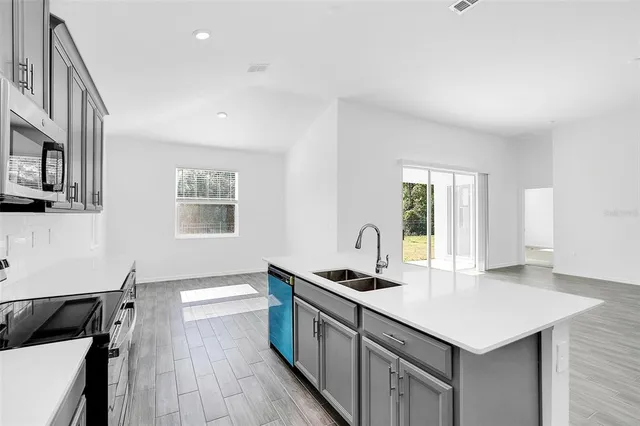 a kitchen with a sink cabinets and wooden floor