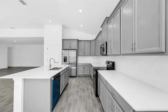a kitchen with a sink stove and cabinets
