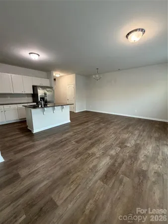 a view of a kitchen with kitchen island a sink wooden floor and a stove