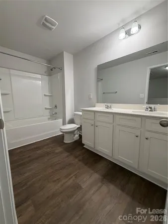 a bathroom with a double vanity sink a mirror and a bathtub