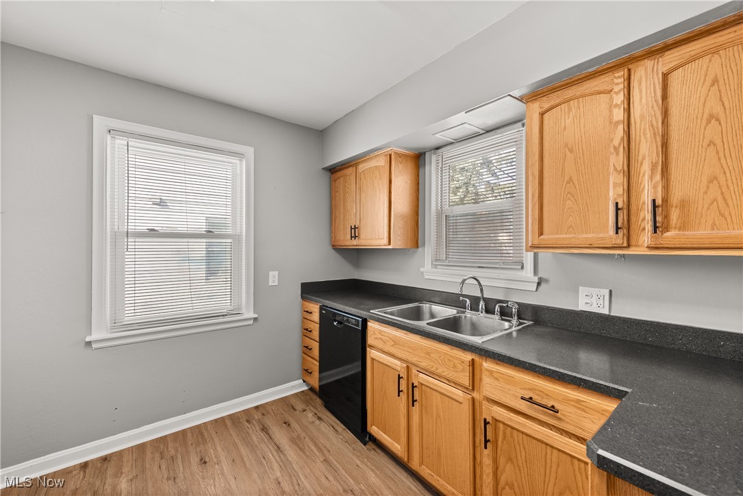 4041 Wilmington Road Cleveland, OH 44121 - Photo 11 of 38 Kitchen featuring dark countertops, black dishwasher, and light wood-type flooring