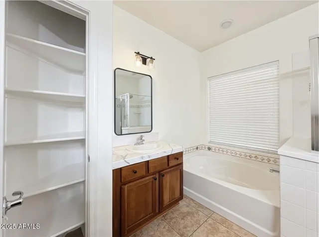 a spacious bathroom with a granite countertop sink and a mirror