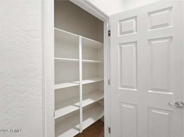 an empty room with a window and a ceiling fan