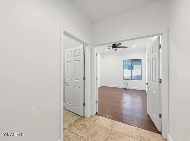 an empty room with wooden floor and ceiling fan