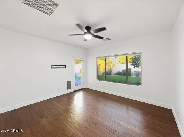 a view of an empty room and window and wooden floor