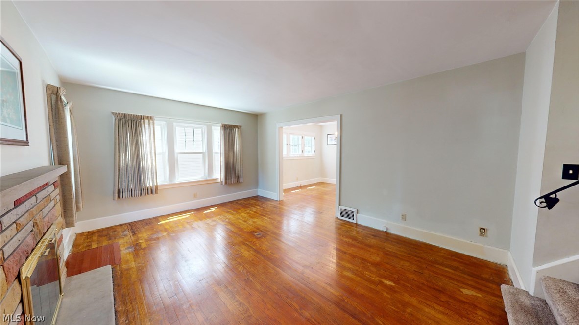 3988 Navahoe Road Cleveland Heights, OH 44121 - Photo 4 of 31 Unfurnished living room featuring a fireplace and wood-type flooring