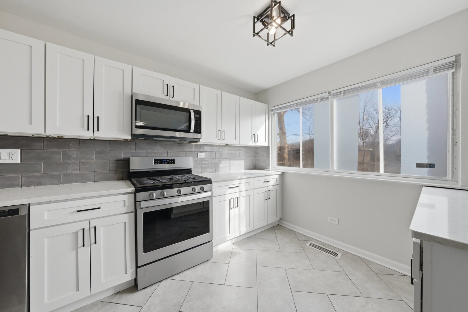 74 West 140th Street Riverdale, IL 60827 - Photo 14 of 37 a kitchen with cabinets stainless steel appliances and a window