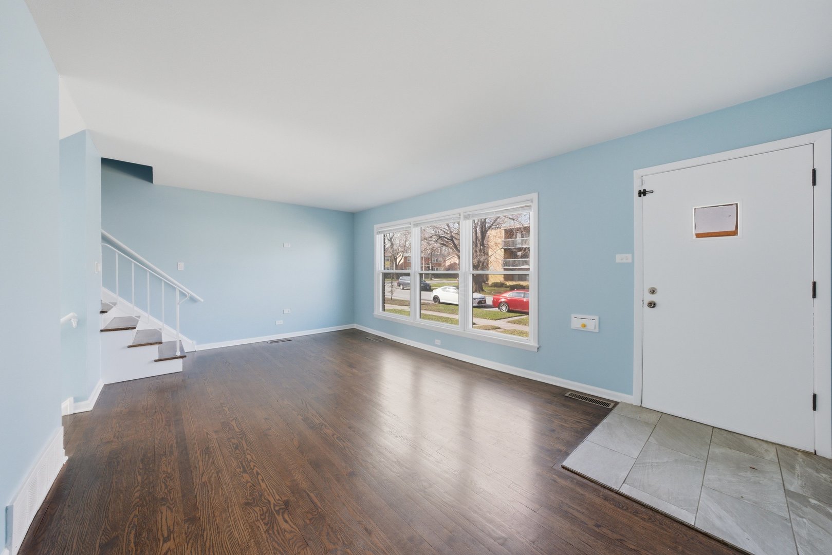 74 West 140th Street Riverdale, IL 60827 - Photo 4 of 37 an empty room with wooden floor and windows