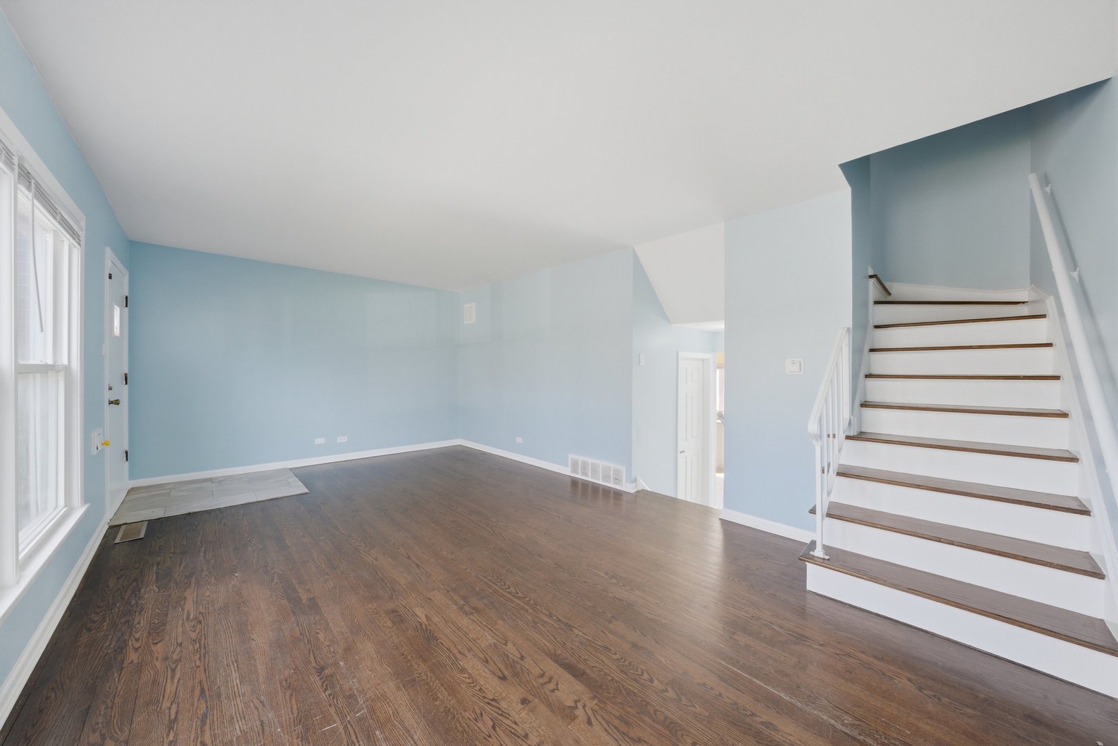 74 West 140th Street Riverdale, IL 60827 - Photo 5 of 37 a view of an empty room with wooden floor and stairs