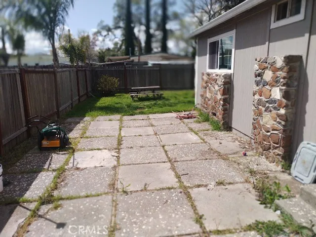 a view of backyard with potted plants and a bench