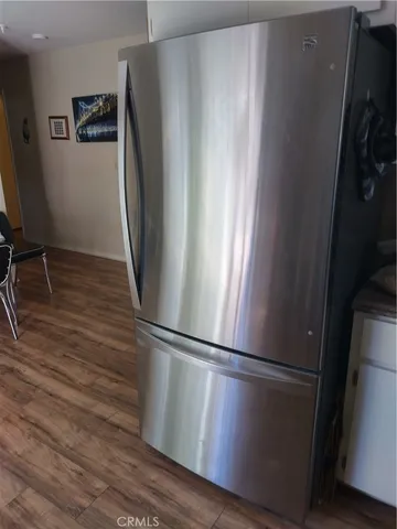 a view of a refrigerator in kitchen and wooden floor