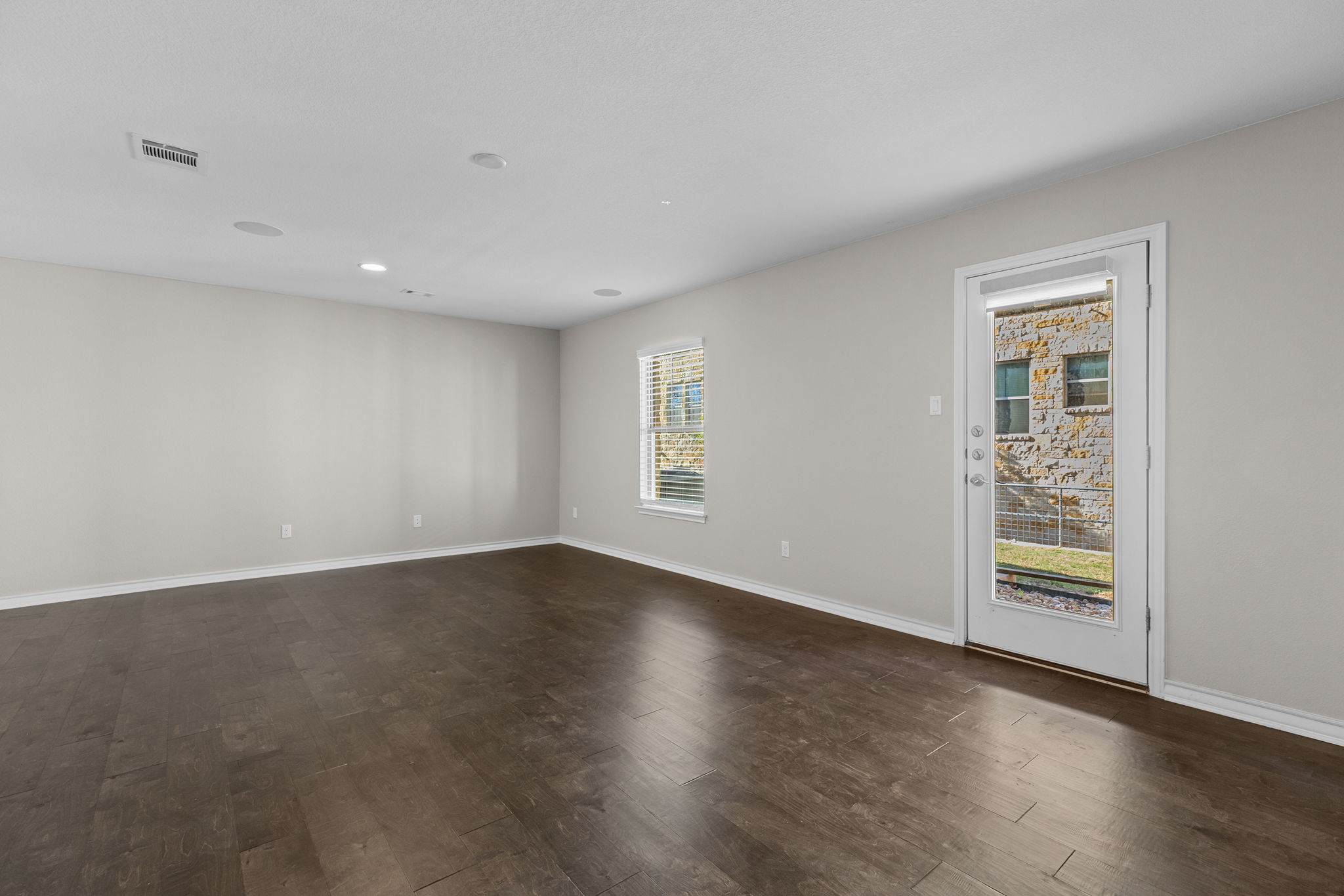 1125 Highknoll Lane Georgetown, TX 78628 - Photo 16 of 40 Empty room featuring dark wood-style floors and recessed lighting