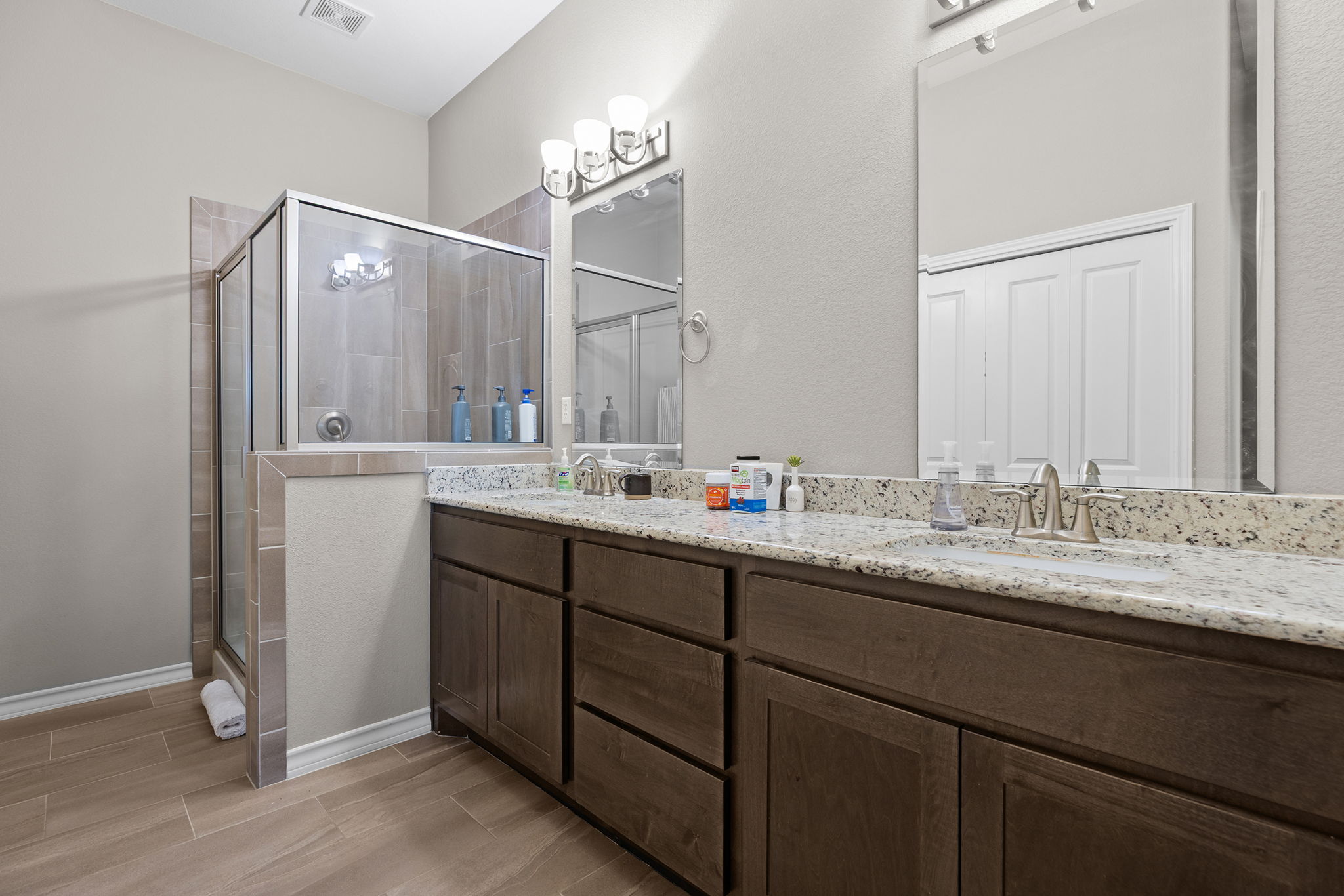 1125 Highknoll Lane Georgetown, TX 78628 - Photo 24 of 40 Bathroom with a shower stall, double vanity, and wood tiled floors