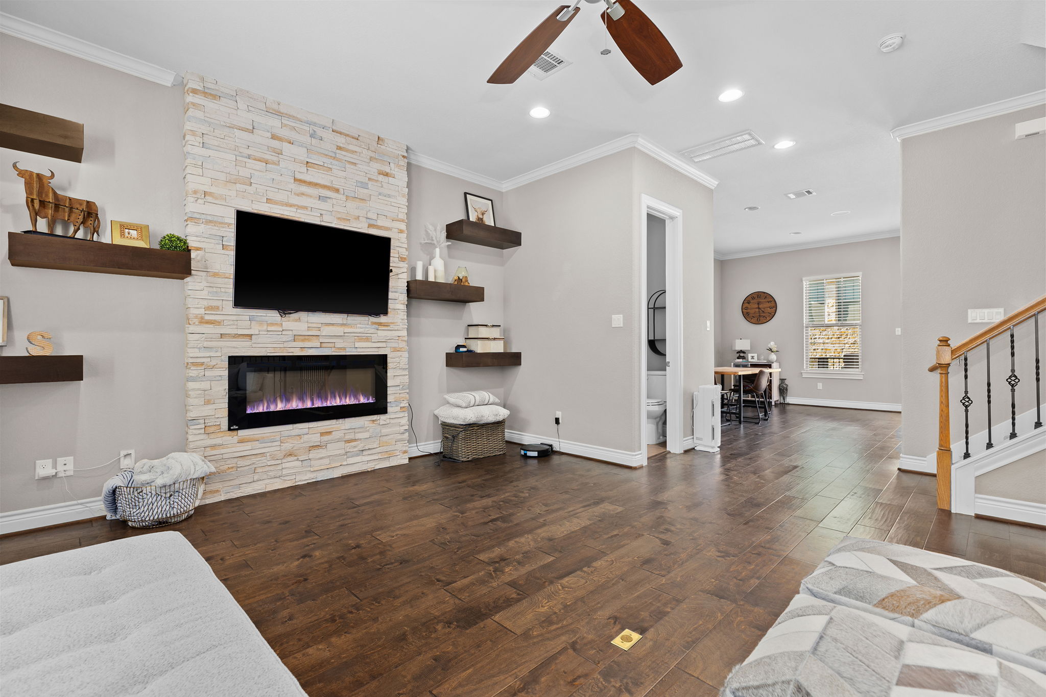 1125 Highknoll Lane Georgetown, TX 78628 - Photo 3 of 40 Living area with a stone fireplace, a ceiling fan, dark wood-style floors, crown molding, and recessed lighting