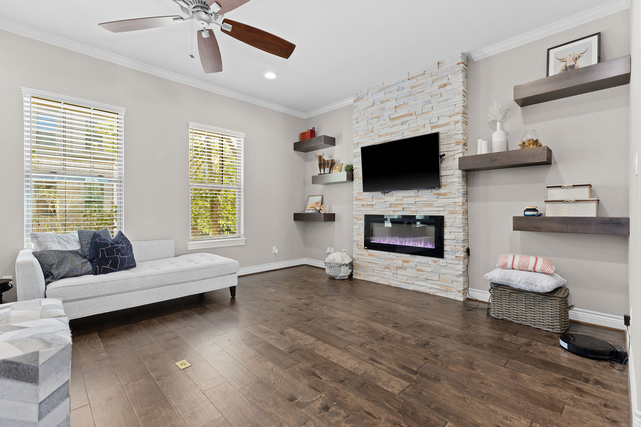 1125 Highknoll Lane Georgetown, TX 78628 - Photo 4 of 40 Living area featuring crown molding, dark wood finished floors, ceiling fan, a stone fireplace, and recessed lighting