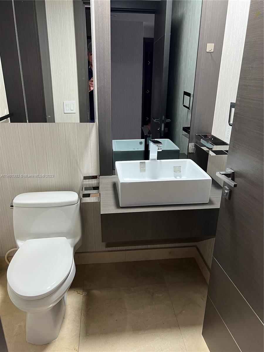 901 Brickell Key Boulevard, Unit 2506 Miami, FL 33131 - Photo 15 of 24 a white toilet sitting next to a bathroom sink
