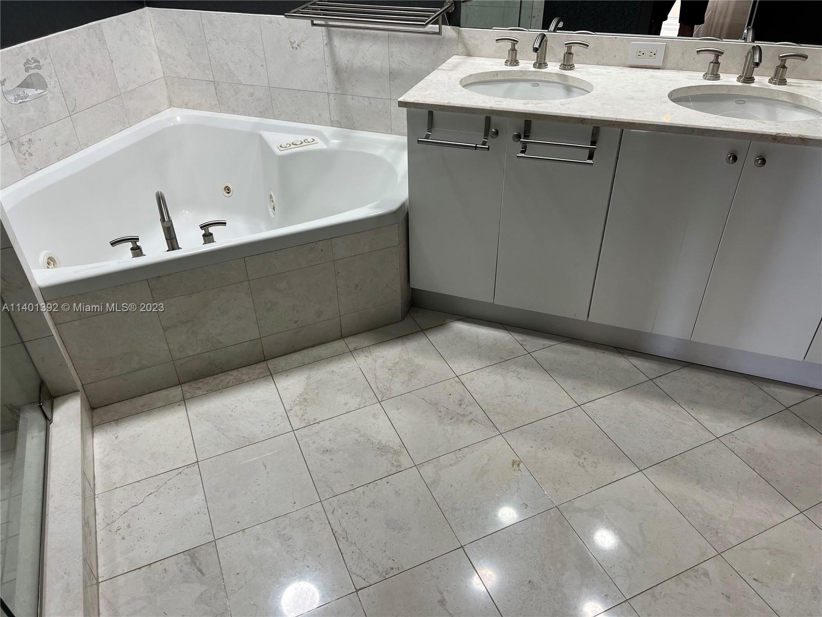 901 Brickell Key Boulevard, Unit 2506 Miami, FL 33131 - Photo 17 of 24 a bathroom with a bathtub sink and mirror