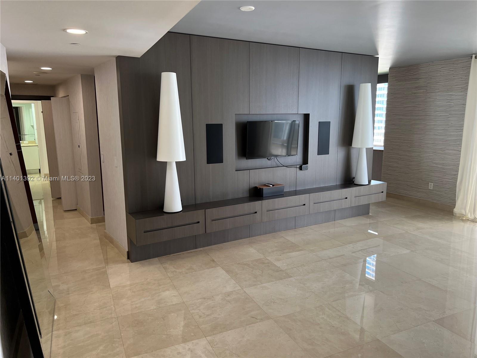 901 Brickell Key Boulevard, Unit 2506 Miami, FL 33131 - Photo 2 of 24 a living room with furniture and a flat screen tv