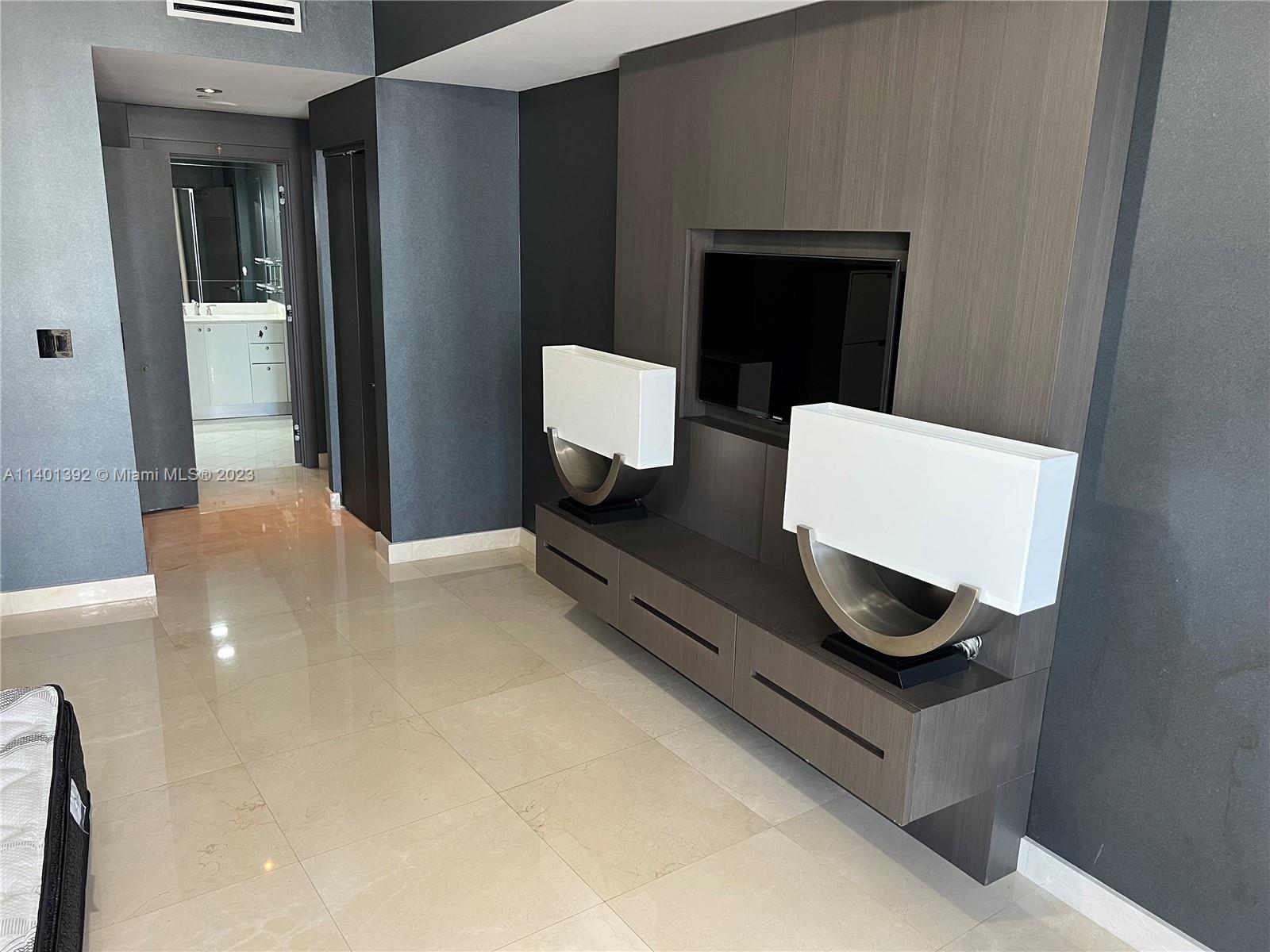 901 Brickell Key Boulevard, Unit 2506 Miami, FL 33131 - Photo 4 of 24 a living room with a couch and a coffee table