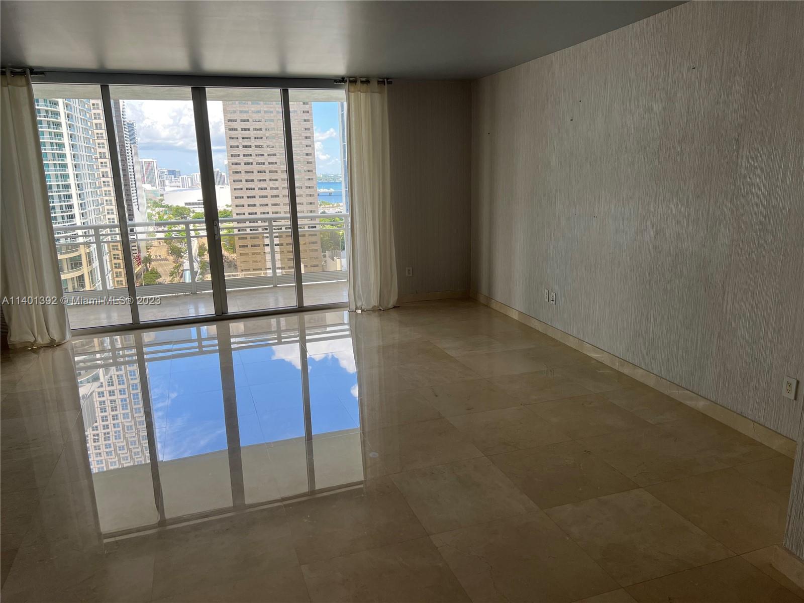 901 Brickell Key Boulevard, Unit 2506 Miami, FL 33131 - Photo 7 of 24 an empty room with windows