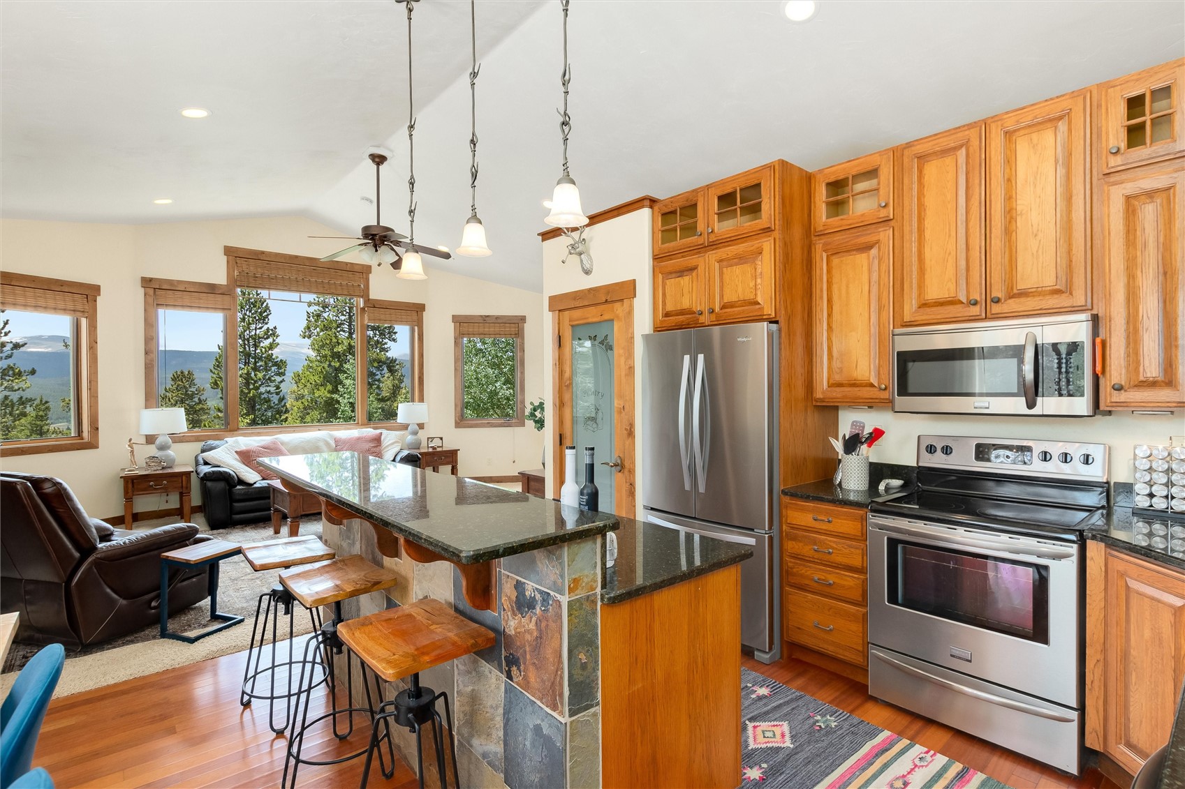 592 Ponderosa Road Fairplay, CO 80440 - Photo 18 of 45 a kitchen with stainless steel appliances granite countertop a stove a refrigerator a kitchen island a dining table and chairs with the wooden floor