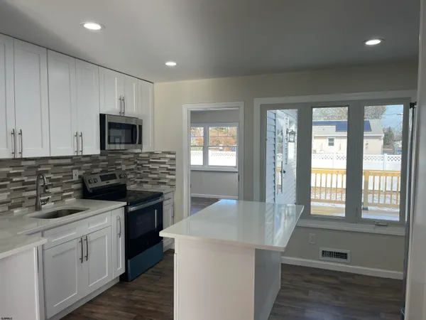 a kitchen with stainless steel appliances granite countertop a refrigerator a sink and a stove