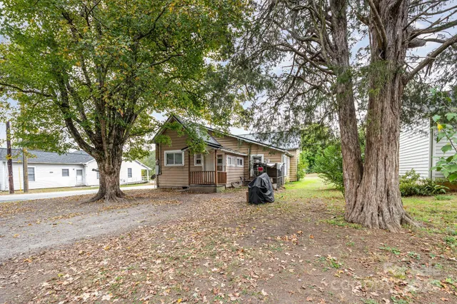 front view of a house with a large tree and a big yard