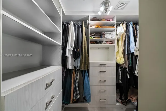 a view of walk in closet with clothes and shoes