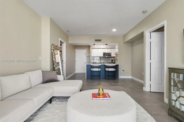 a living room with furniture and kitchen view