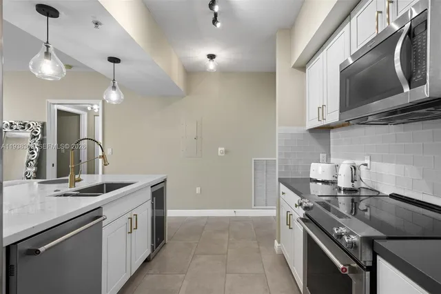 a kitchen with stainless steel appliances granite countertop a sink a stove and a microwave