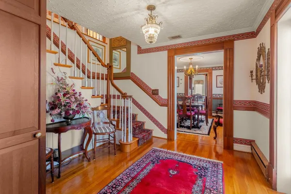 a view of a dining room with furniture a chandelier and wooden floor