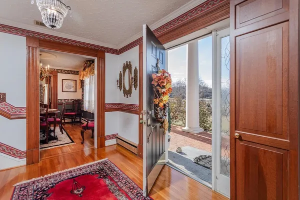 a dining room with furniture a chandelier and wooden floor
