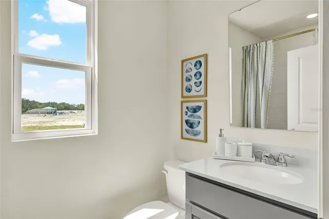 a bathroom with a granite countertop sink mirror and a toilet