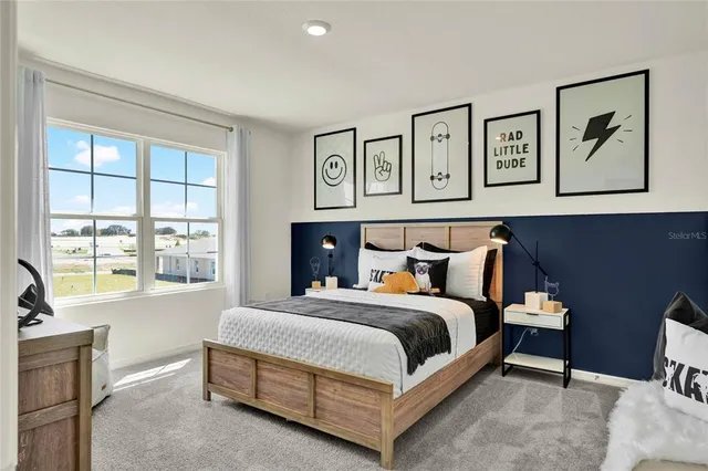 a bedroom with a bed painting on wall and a large window