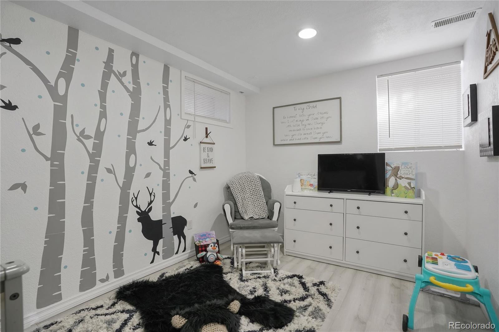 9201 West 104th Place Westminster, CO 80021 - Photo 16 of 29 a living room with furniture and a flat screen tv