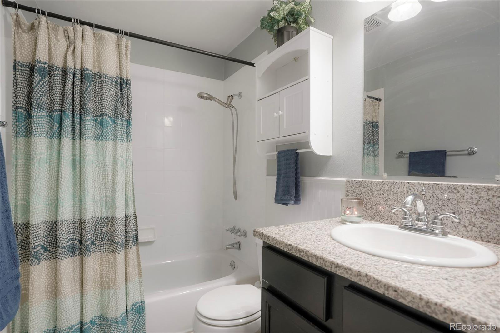 9201 West 104th Place Westminster, CO 80021 - Photo 20 of 29 a bathroom with a granite countertop sink toilet and shower