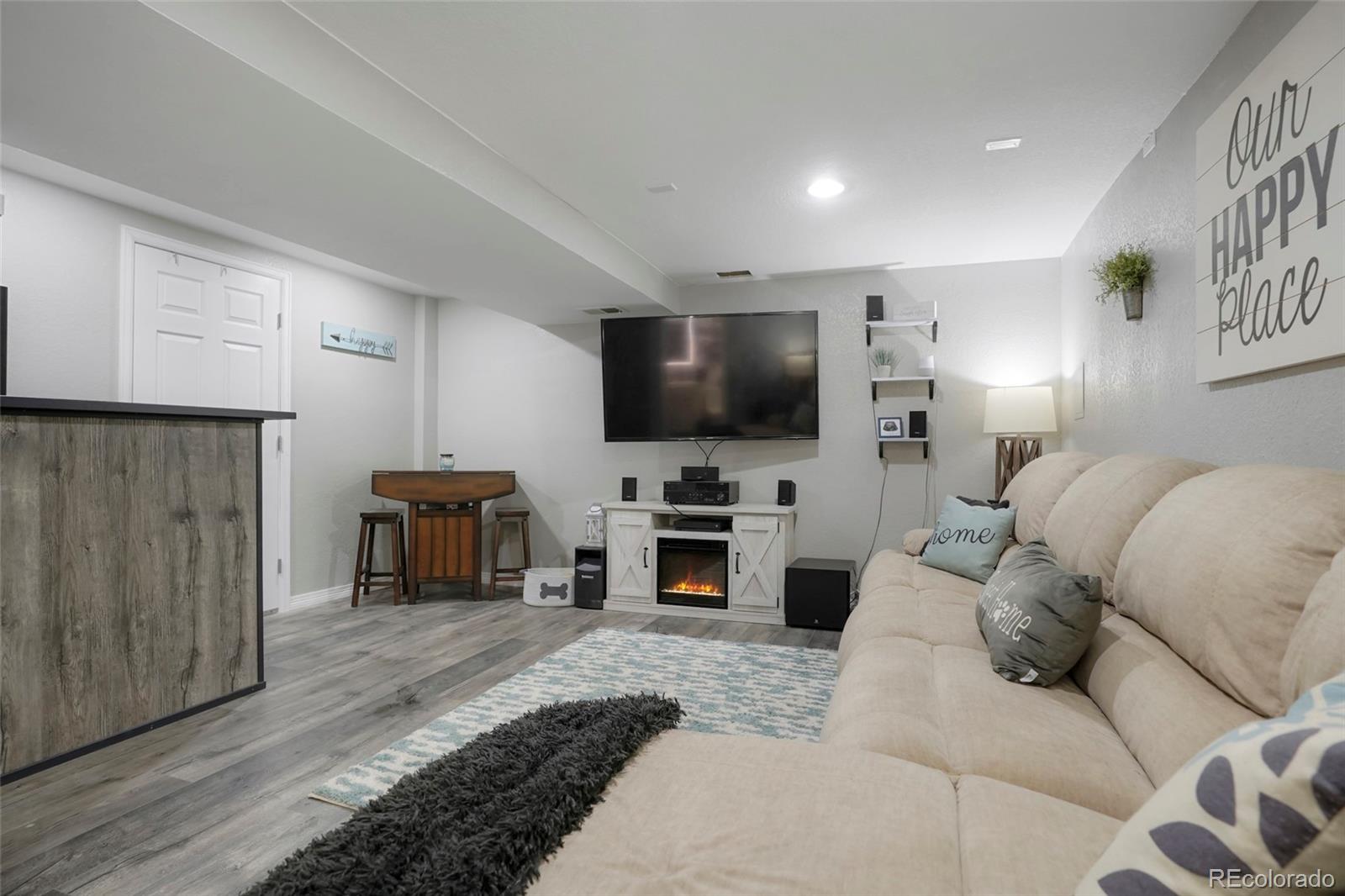 9201 West 104th Place Westminster, CO 80021 - Photo 22 of 29 a living room with furniture and a flat screen tv