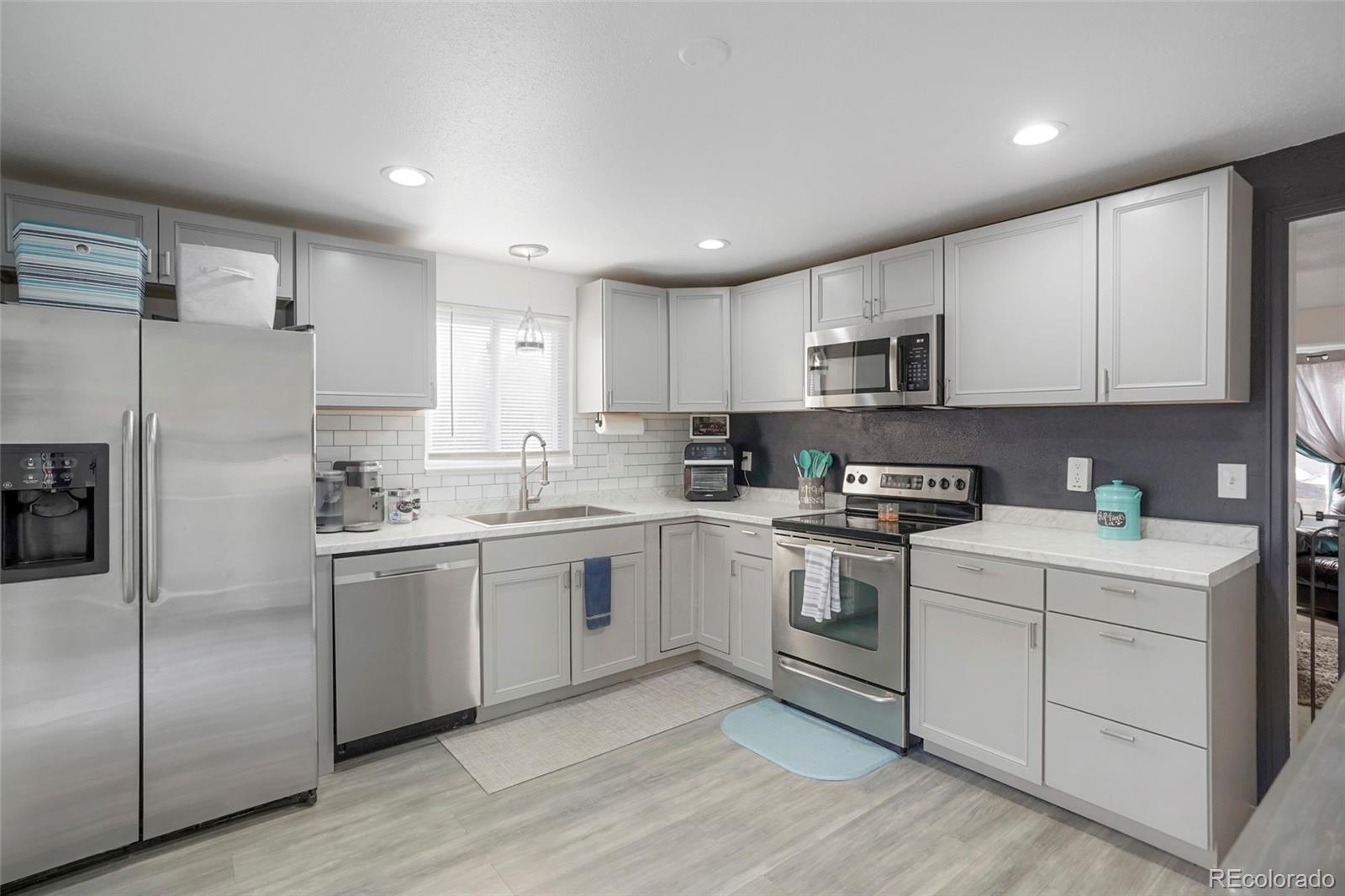 9201 West 104th Place Westminster, CO 80021 - Photo 8 of 29 a kitchen with cabinets stainless steel appliances and a counter space