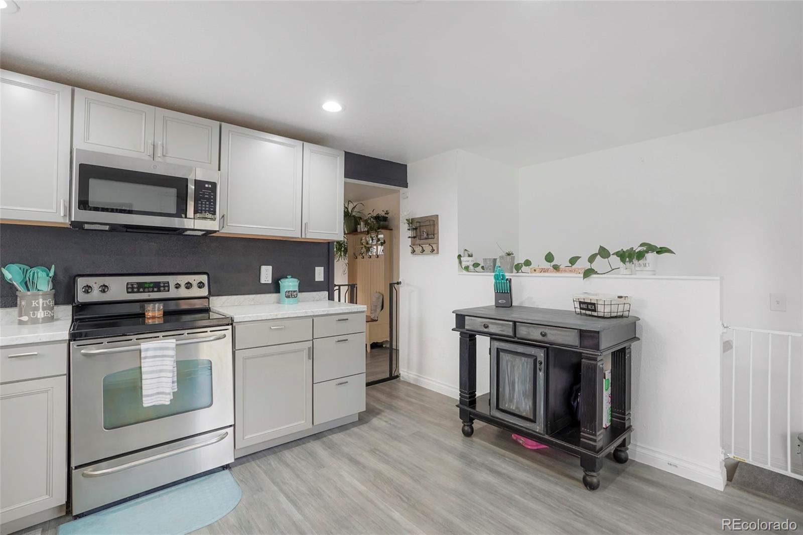 9201 West 104th Place Westminster, CO 80021 - Photo 9 of 29 a kitchen with stainless steel appliances granite countertop a stove a sink and a microwave