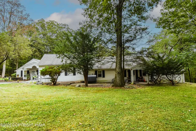 a view of a house with a yard and trees