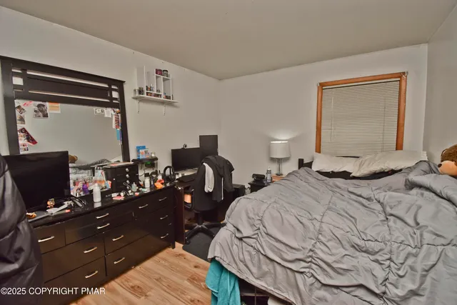 a bedroom with a bed and a flat tv screen on the dresser