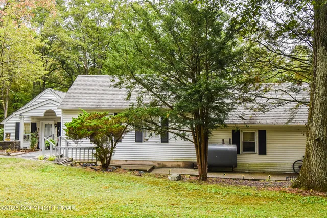 a front view of house with yard and trees