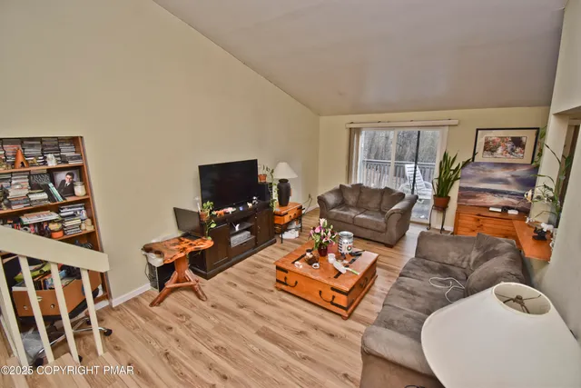 a living room with furniture a flat screen tv and a window