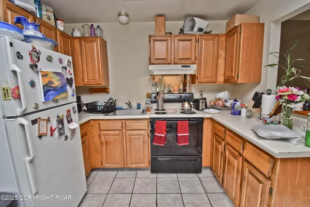 a kitchen with stainless steel appliances granite countertop a sink and a refrigerator
