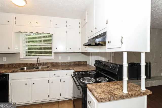 a kitchen with white cabinets and appliances